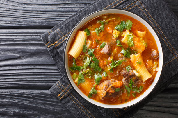 soup joumou or haitian beef and pumpkin soup is a famous mildly spicy soup prepared with beef and vegetables and also rigatoni pasta closeup in the plate. horizontal top view - portion pumpkin vegetable black imagens e fotografias de stock