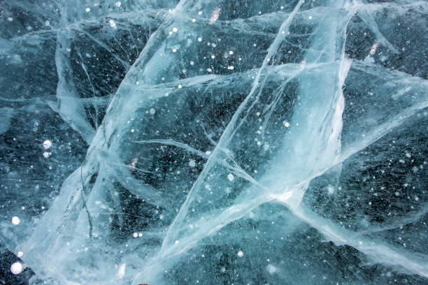 istock Cracks in the ice with frosted air bubbles inside. 1288976263
