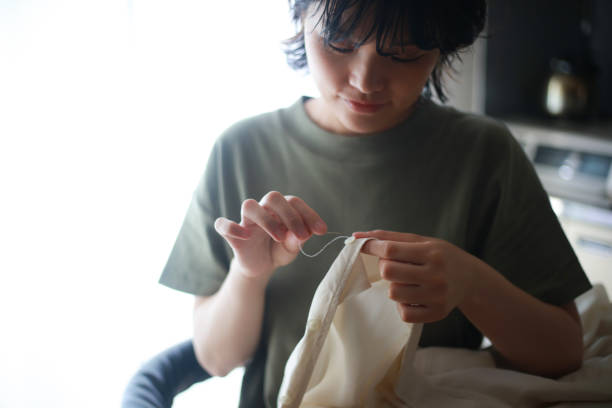 istock Woman putting buttons on clothes 1288977660