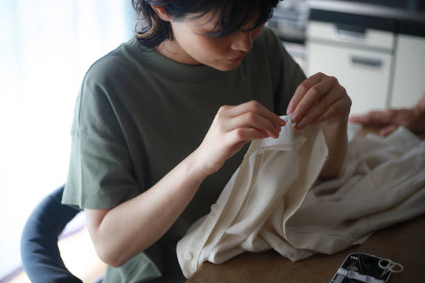 istock Woman putting buttons on clothes 1288977746