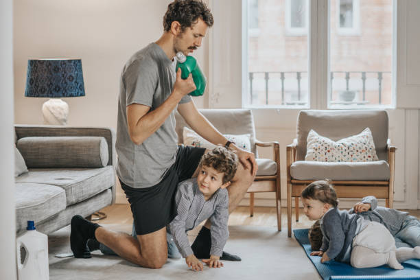 istock Father with children exercising at home 1288978842