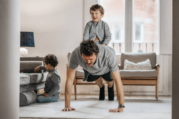 istock Father with children exercising at home 1288978860