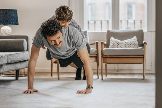 ojciec z dziećmi ćwiczący w domu - exercising men push ups muscular build zdjęcia i obrazy z banku zdjęć