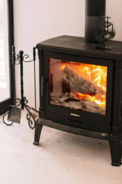istock Modern cast iron fireplace with a flame in the house, apartment. Soft selective focus. 1288980192