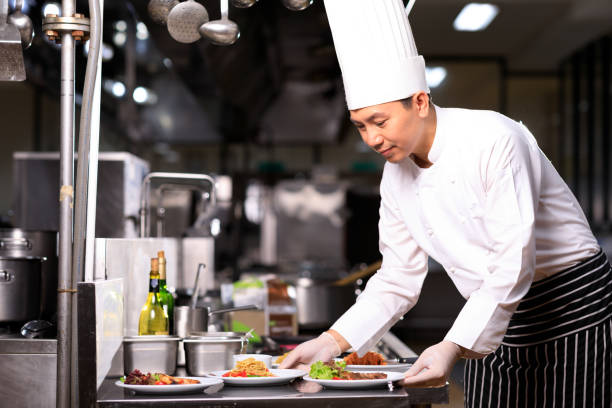 istock Asian Male chef presenting the dish in the kitchen. Selective focus. 1288980314