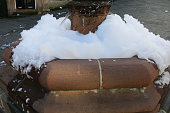 Close-up image of town fountain overflowing with soap sud foam with cascading water, teenage prank, focus on foreground
