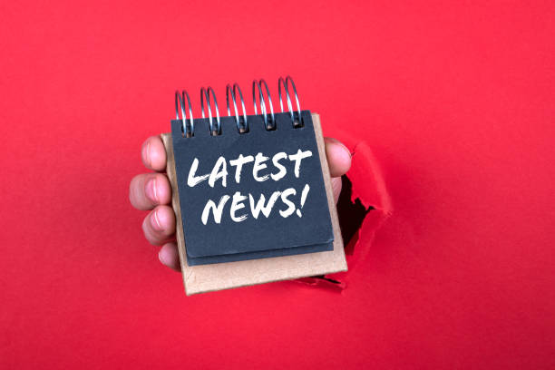 istock Latest news concept. Notebook in woman hand. Red background 1288982420