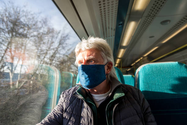 istock Senior man wearing protective face mask in train carriage 1288982500