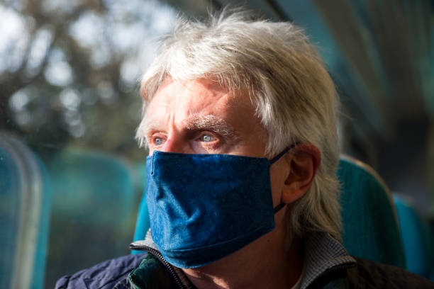 istock Senior man wearing protective face mask in train carriage 1288982503