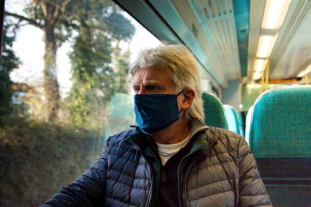 istock Senior man wearing protective face mask in train carriage 1288982512