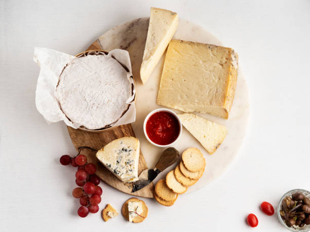 quesos artesanales, queso, quesos surtidos en un plato de pizarra - aperitivos de degustación, queso hecho en la granja, - cheese and crackers fotografías e imágenes de stock
