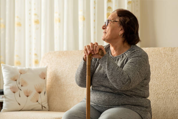 istock Senior woman looking thoughtful in home 1288984093