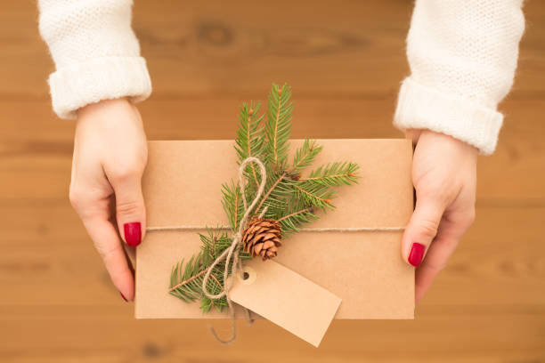 istock Female hands hold waste-free gift boxes and recyclable eco-friendly packaging for various holidays, Christmas, Valentine's Day, on a wooden background. Zero waste concept, environmental protection 1288984318