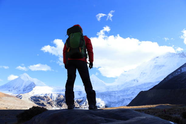istock Successful woman backpacker hiking in winter mountains 1288985564