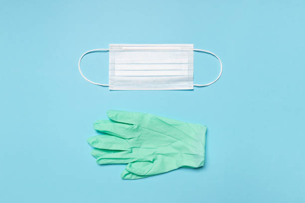 istock Medical mask and gloves on blue background 1288985582