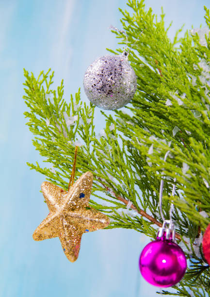 Happy Christmas! Pine tree branch decorated with shiny golden stars, red and pink glitter christmas balls stock photo