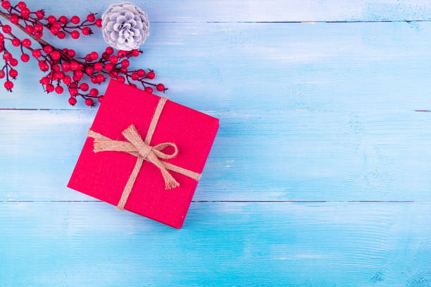 New Year Background! Red christmas gift box and cone on blue wood background stock photo