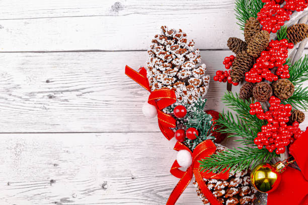 Christmas concept with Butcher's Broom and colorful cones on white wood background stock photo