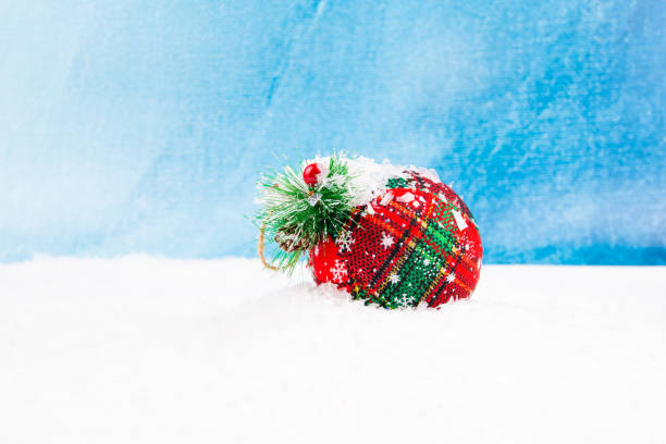 red and green new year ornament with snow on it with blue background stock photo