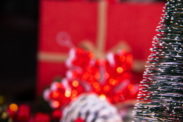 close-up of a snowy Christmas tree with Christmas decorations behind stock photo