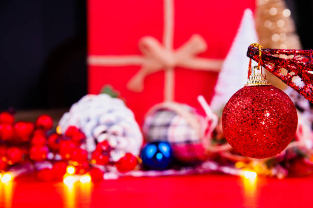 bright silvery red Christmas ball in front of colorful and bright Christmas decorations stock photo