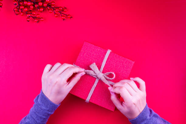Christmas background. Gift boxes with colorful shiny Christmas decorations, cones, star and ball on the whiteboard, and the girl is holding the new year gift box. stock photo