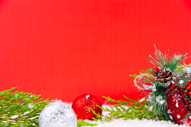 close-up red christmas decorations, snow and pine tree stock photo