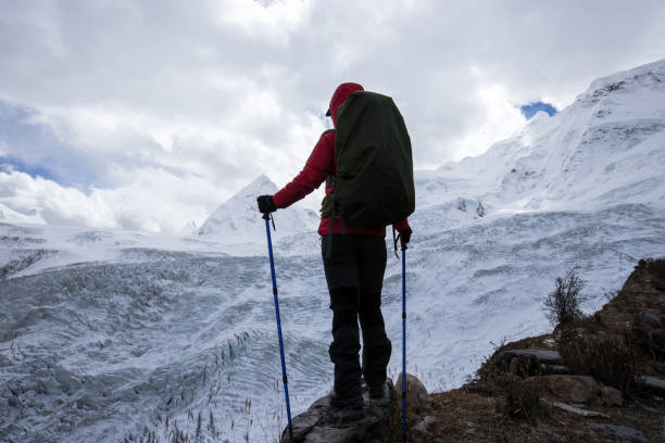 istock Successful woman backpacker hiking in winter mountains 1288987542