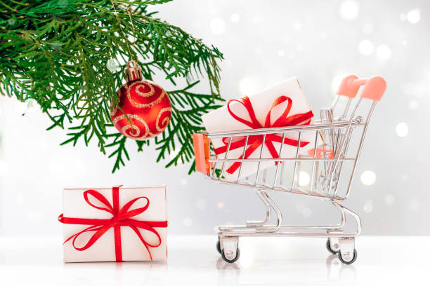 istock New Year shopping. Mini cart with gift boxes on white background. 1288989014