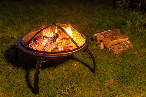 Fire pit in a garden with spare logs