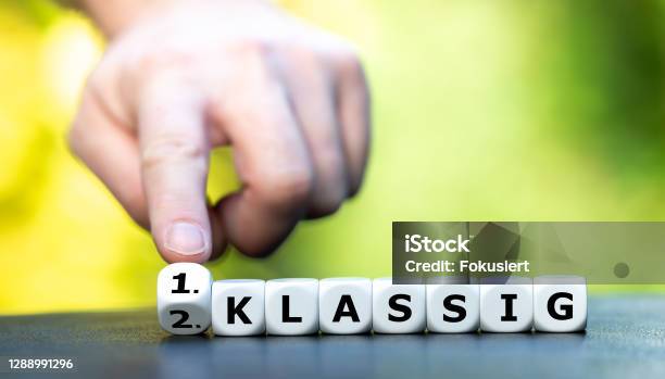 Hand Turns Dice And Changes The German Expression 2 Klassig Stock Photo - Download Image Now