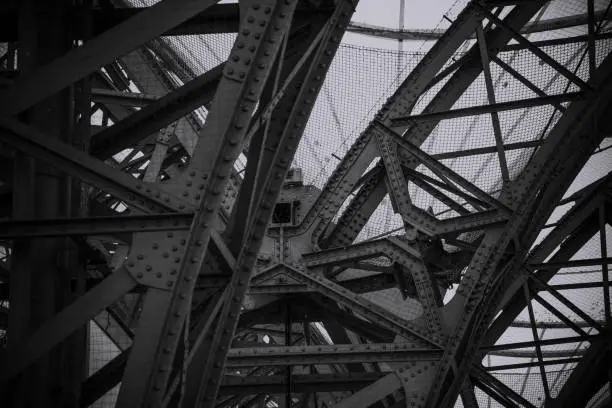 metal constructions of a bridge shot in black and white viewed from low angle