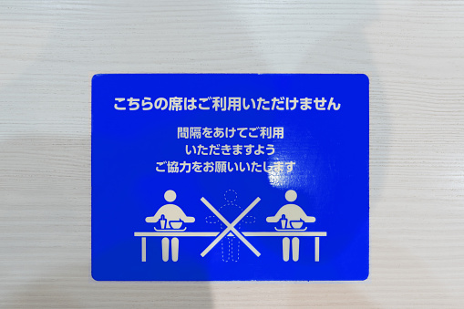 Sticker on a restaurant table advising customers regarding social distancing guidelines during the Coronavirus pandemic.