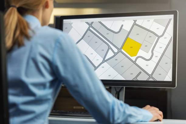 オフィスのコンピュータ上のデジタル地籍地図土地登記データベースを使用して働く女性 - house plan real estate planning ストックフォトと画像