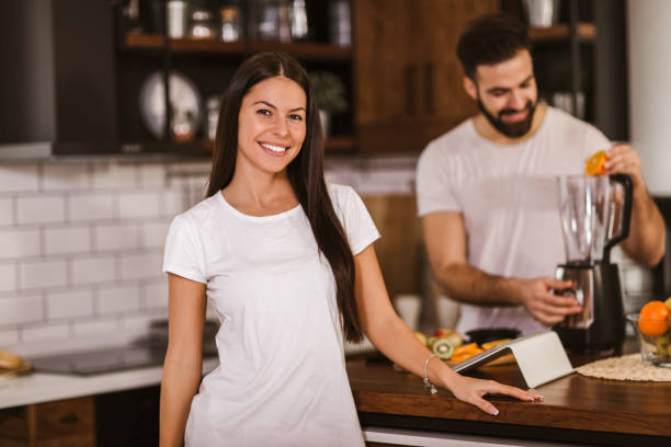 istock Couple making fresh organic juice in kitchen together 1289000489