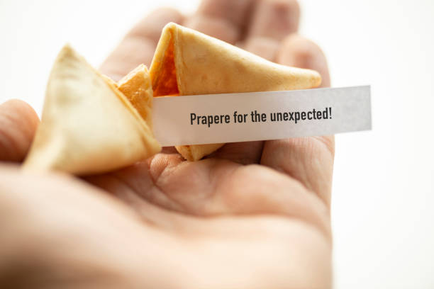 Prepare For The Unexpected A hand holding broken fortune cookie. calm before the storm stock pictures, royalty-free photos & images