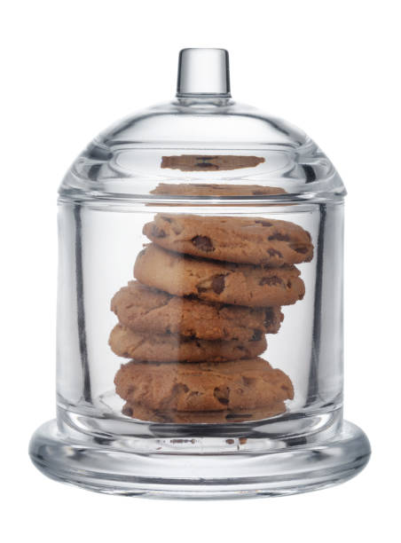 istock Glass cookie jar with chocolate chip cookies inside on white background 1289003463