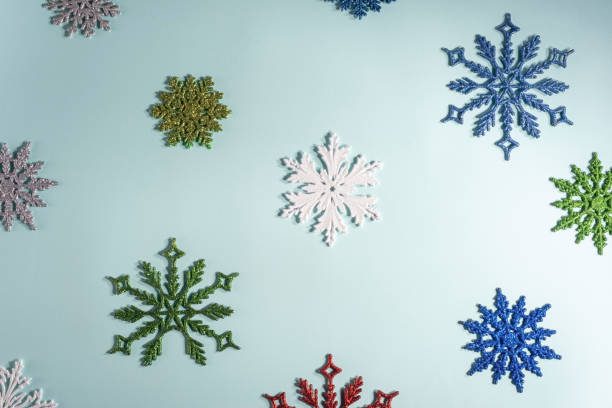 istock flatlay multicolored christmas snowflakes on a blue background. View from above 1289003507