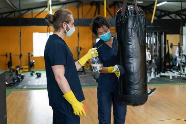 istock Employee couple clean training accessories inside gym 1289003838