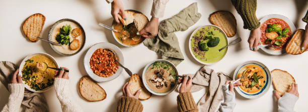 istock Peoples hands eating homemade soup with fresh bread 1289004011