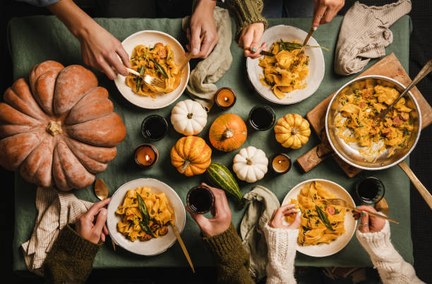 ludzie jedzący makaron z squasha z kiełbasą w święto dziękczynienia - comfort food zdjęcia i obrazy z banku zdjęć