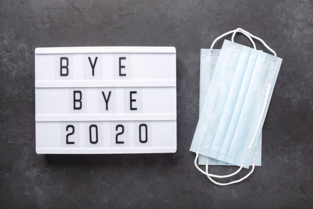 istock Lightbox with text BYE BYE 2020 with medical mask on dark background. Top view. New year celebration. Happy New Year 2021 concepts 1289004787