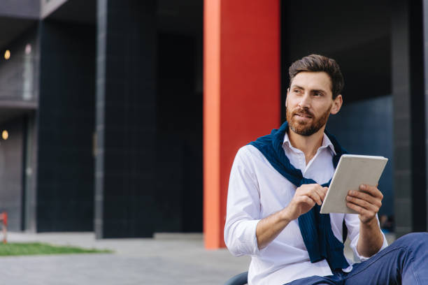 istock Male freelancer working on tablet while sitting outdoors 1289005509