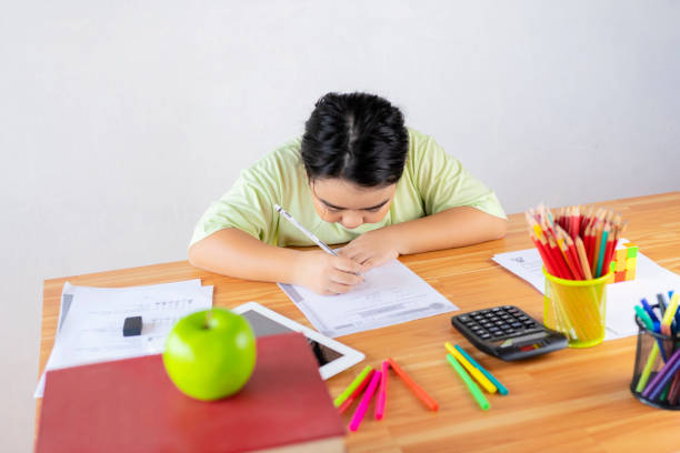 istock Asian children are studying exercises with determination. On the study desk there is study equipment, stationery 1289005533