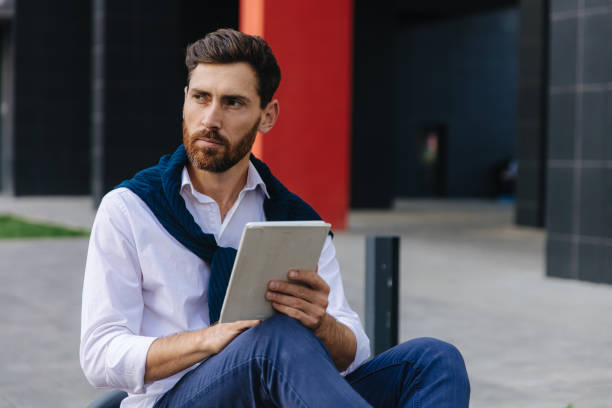 istock Busy man working on digital tablet outside his office 1289006760