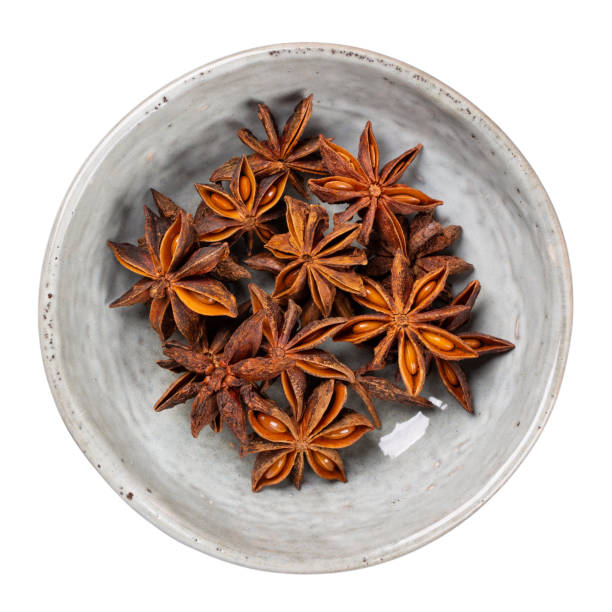 istock Star anise in gray ceramic bowl isolated on white. Top view. 1289007575