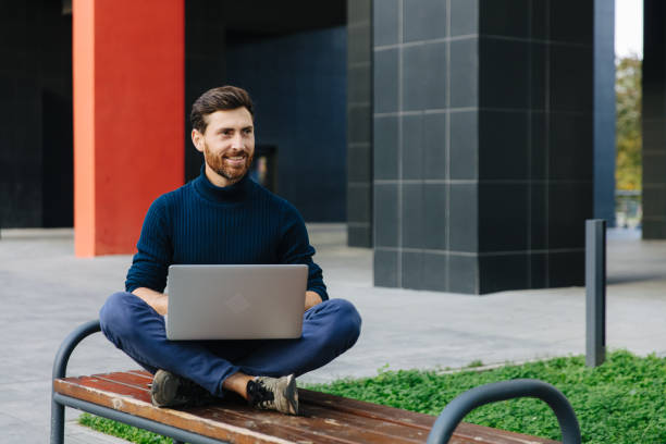 istock Confident businessman using wireless laptop outdoors 1289007662