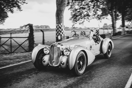 1939 Lagonda V12 tourer driving on a country road. The Lagonda V12 is a car with various body styles produced by the British Lagonda car maker from 1938 to 1940. The car is doing a demonstration drive during the 2017 Classic Days event at Schloss Dyck.