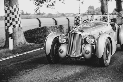 1939 Lagonda V12 tourer driving on a country road. The Lagonda V12 is a car with various body styles produced by the British Lagonda car maker from 1938 to 1940. The car is doing a demonstration drive during the 2017 Classic Days event at Schloss Dyck.