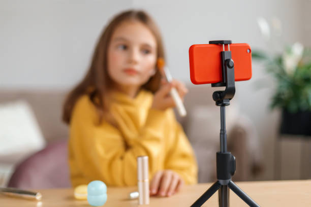 istock Cute girl recording video tutorial on smartphone in her room 1289016583